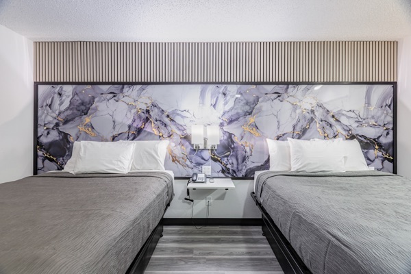 Two queen beds with remodeled headboard wall